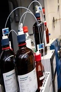 Amber reagent bottles connected to lab instrumentation