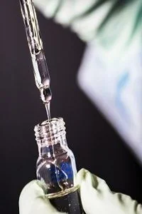 Pipette dispensing a sample into a glass vial